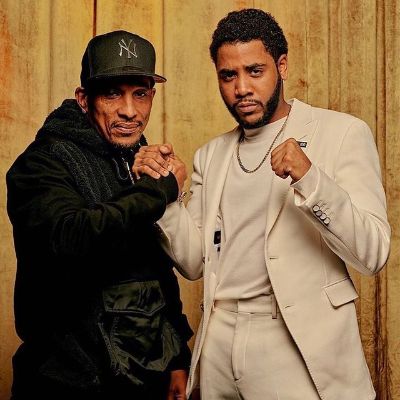 Both are posing at the camera with Jhareel wearing a suit and Korey wearing a black hoodie with NY cap.